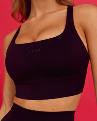 Woman wearing Twist Long Line Sports Bra in Black 