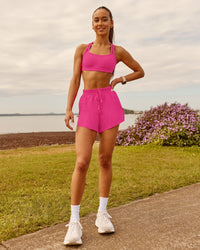 Woman wearing Velocity Sports Bra - Ultra Pink | Model:Zara | Size:2XS