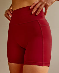 Woman wearing Fusion Ultra High-Rise 6" Short Pockets - Cherry Red | Model:Shae | Size:S