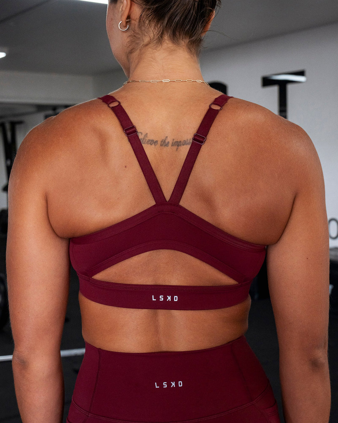 Woman wearing Momentum Sports Bra - Cordovan