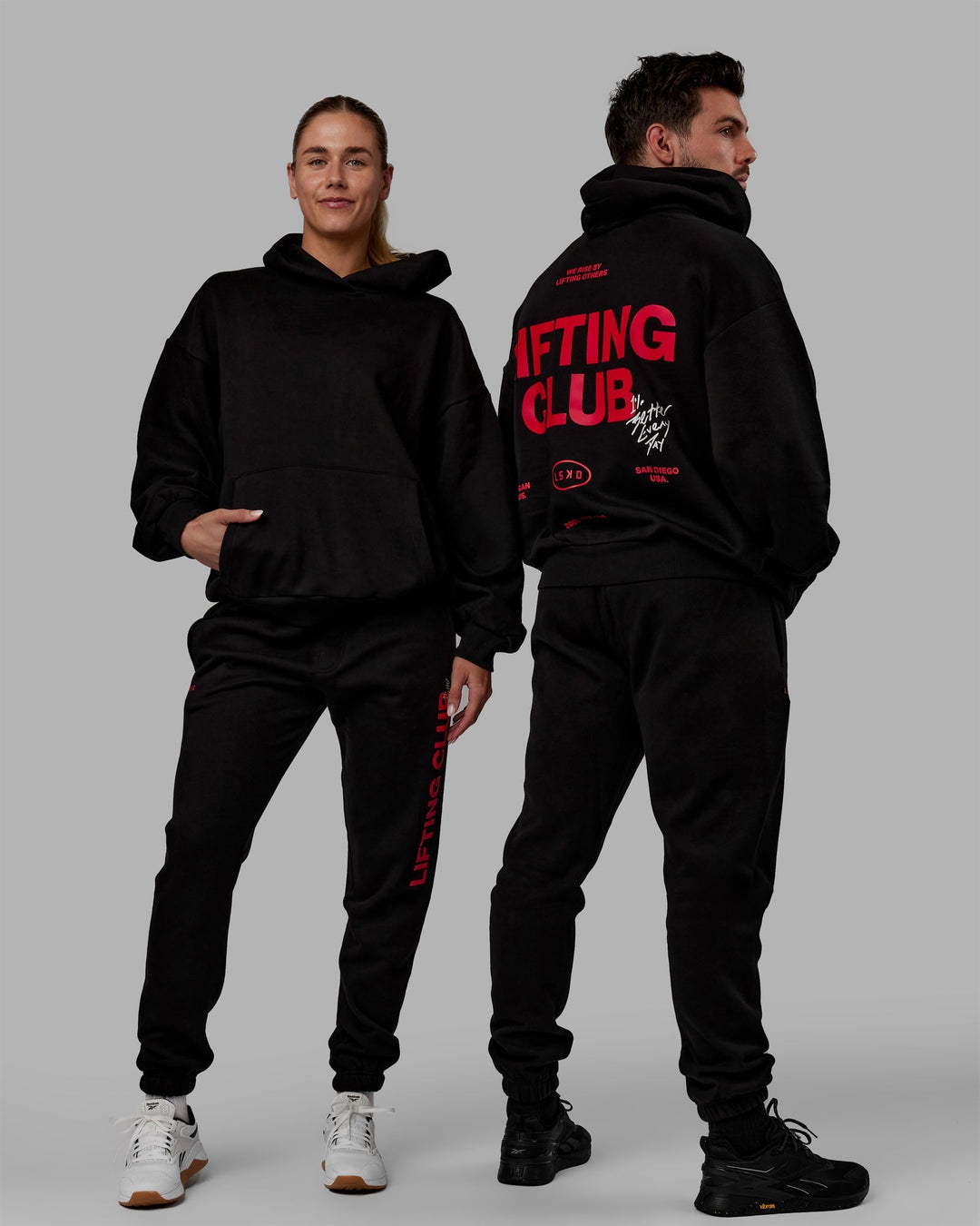 Duo wearing Unisex Lifting Club Hoodie Oversize - Black-Red