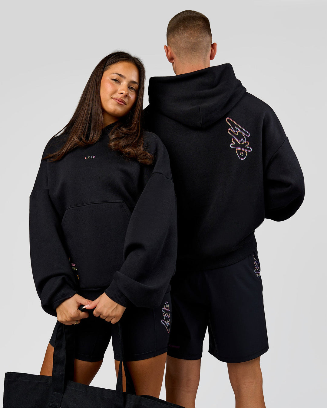 Duo wearing Pride Sticker Boxy Hoodie - Black | Model:Bianca | Size:XS | Model:Albert | Size:M