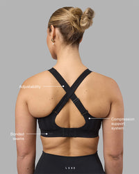 Woman wearing Stability Sports Bra - Black | Model:Amy | Size:S (D-E Cup)