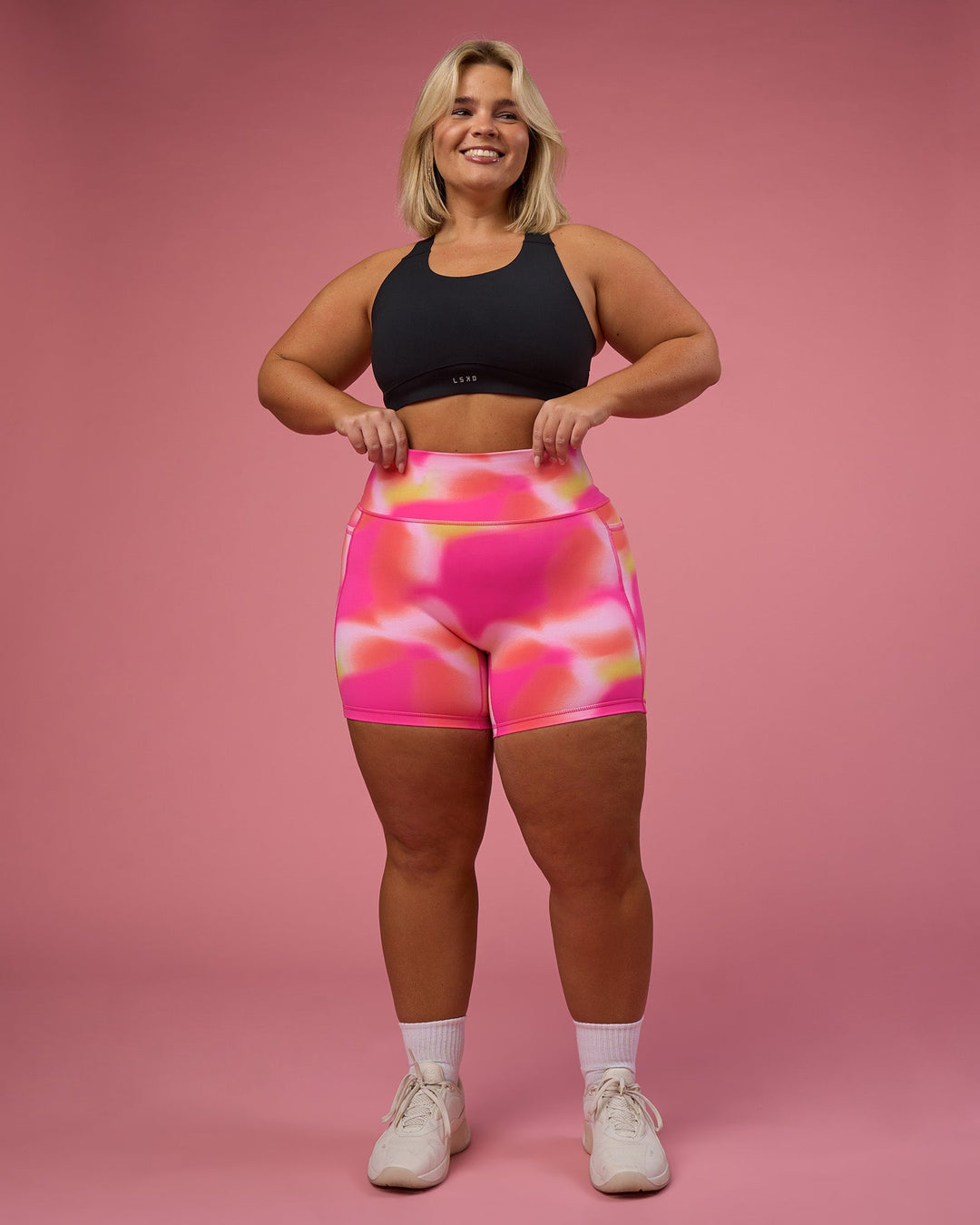 Woman wearing Fusion Ultra High-Rise 6" Short Pockets - Pink Glow Print | Model:Bianca | Size:L
