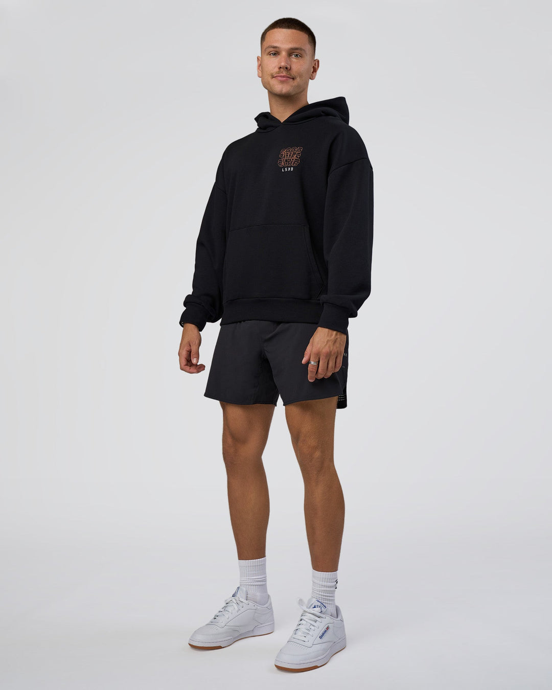 Man wearing GTC CVC Fleece Unisex Oversized Hoodie - Black-Cantaloupe | Model:Nikola | Size:L
