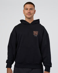 Man wearing GTC CVC Fleece Unisex Oversized Hoodie - Black-Cantaloupe | Model:Nikola | Size:L