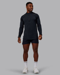 Man wearing AeroFLX+ Seamless Half Zip Long Sleeve Tee - Black/Black | Model:Sam | Size:L