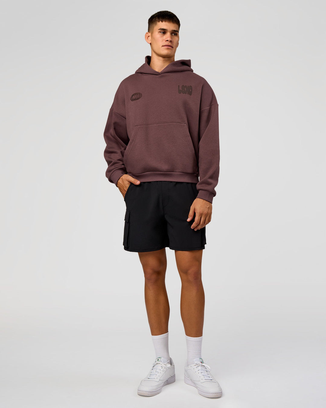 Man wearing Static Grit Unisex Boxy Hoodie - Cocoa Powder-Hot Chocolate | Model:Jackson | Size:L