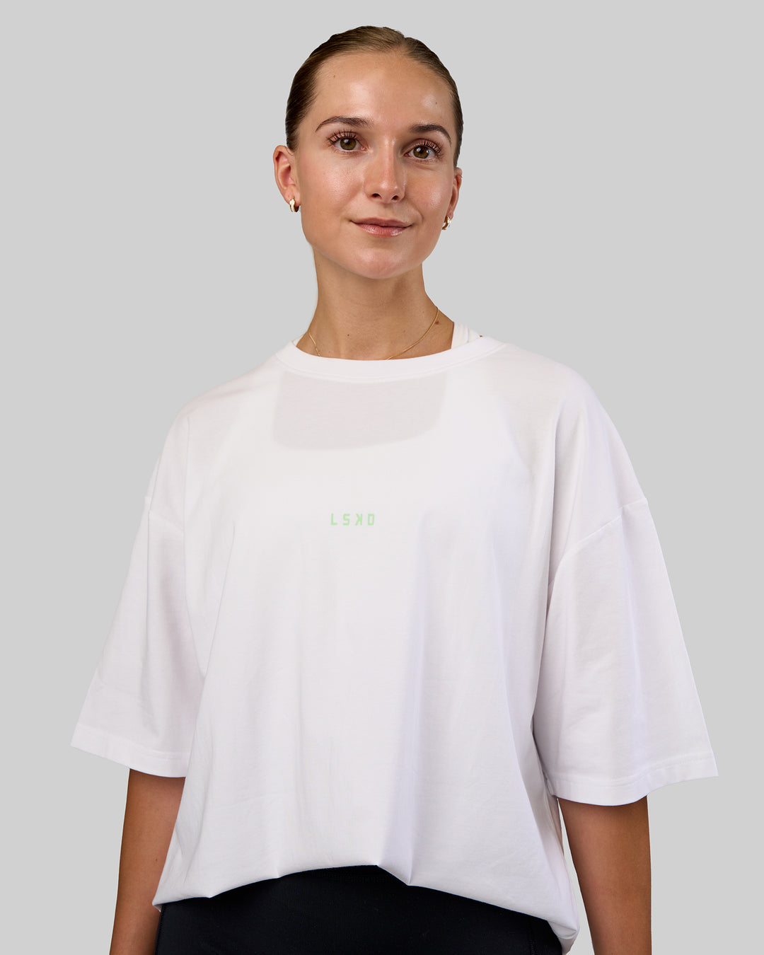 Woman wearing Together We Rise FLXCotton Oversized Tee - White-Solar Lime | Model:Myrte | Size:L