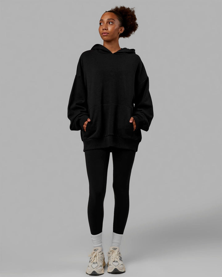 Woman wearing Unisex MVP Hoodie Oversize - Black