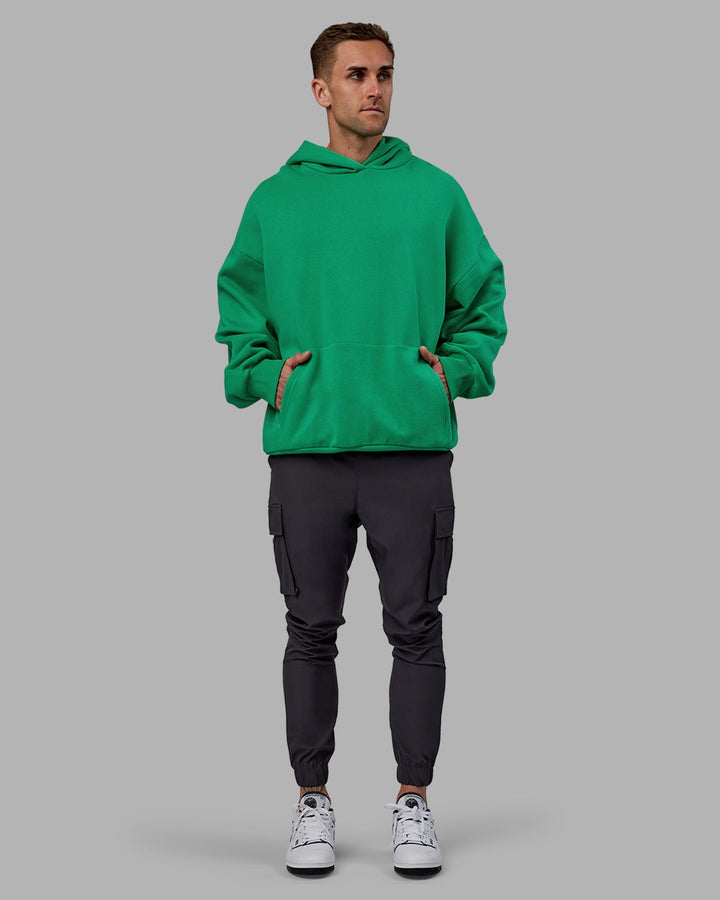 Man wearing Unisex We Rise Hoodie Oversize - Impact Green-White
