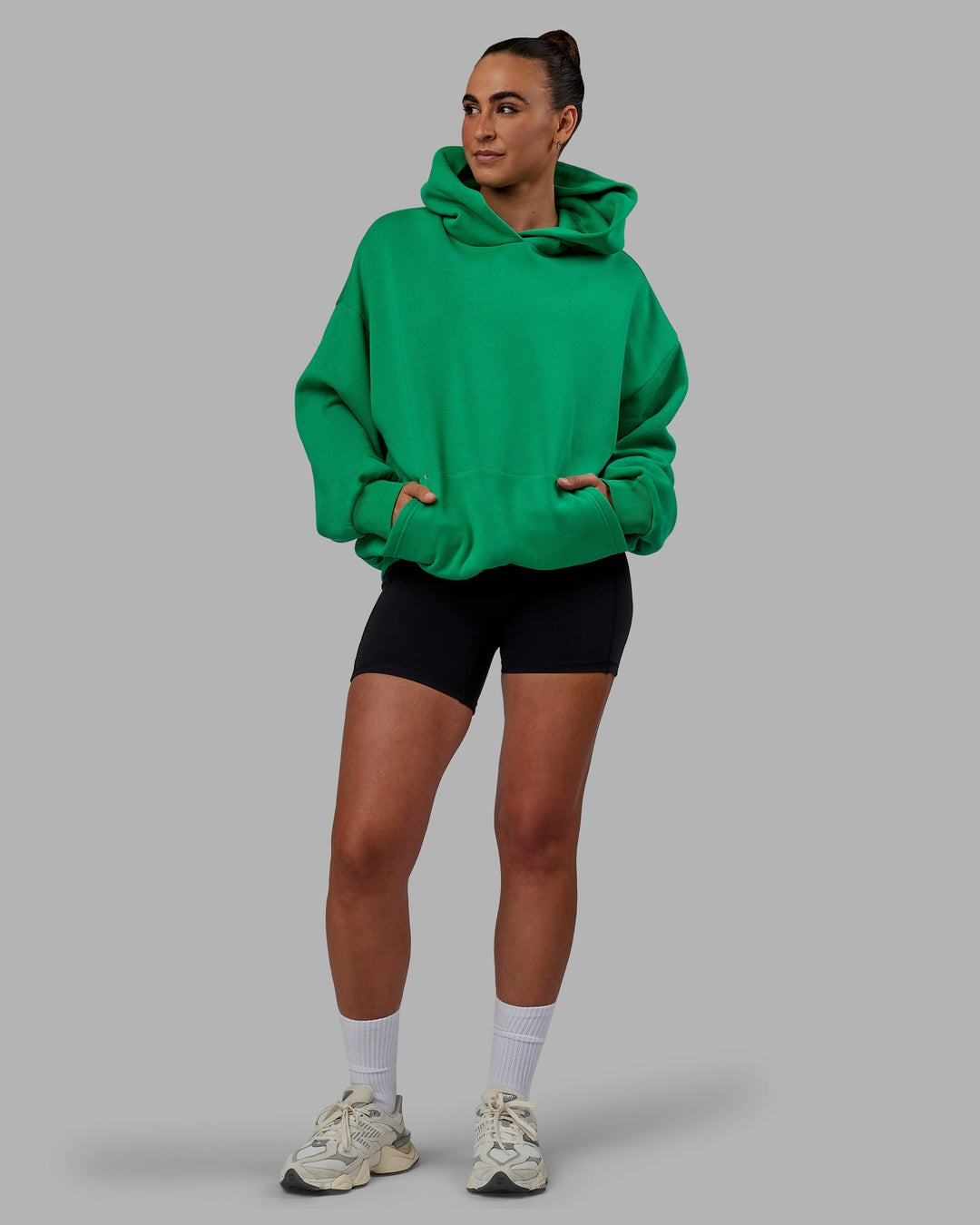 Woman wearing Unisex We Rise Hoodie Oversize - Impact Green-White