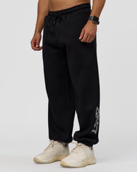 Man wearing Static Grit Baggy Track Pant - Black-Alloy | Model:Jaiden | Size:M