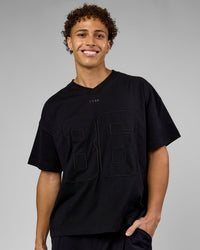 Man wearing 86 V-Neck Oversized Tee - Black-Black | Model:Leandro | Size:M