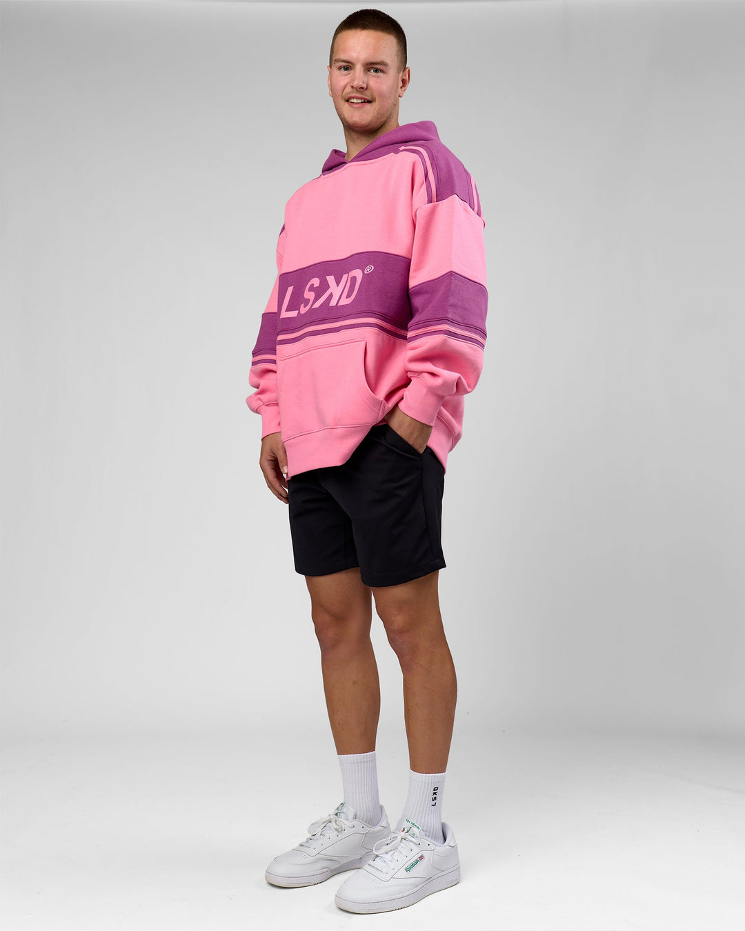 Man wearing A-Team Oversized Hoodie - Candy Pink-Boysenberry | Model:Arran | Size:M