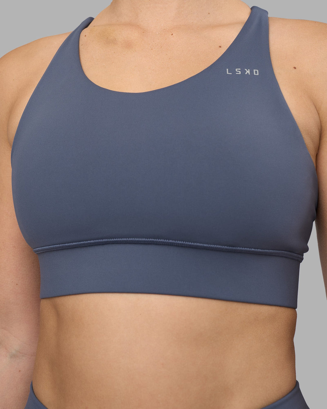 Woman wearing Accelerate Sports Bra - Night Shadow | Model:Amy | Size:M