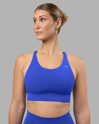Woman wearing Accelerate Sports Bra - Power Cobalt | Set:true | Angle:front | Model:Amy | Size:M
