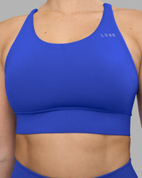 Woman wearing Accelerate Sports Bra - Power Cobalt | Set:true | Angle:closeup | Model:Amy | Size:M
