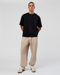 Man wearing Base Baggy Cuffed Track Pant - Shale Beige | Model:Albert | Size:M |