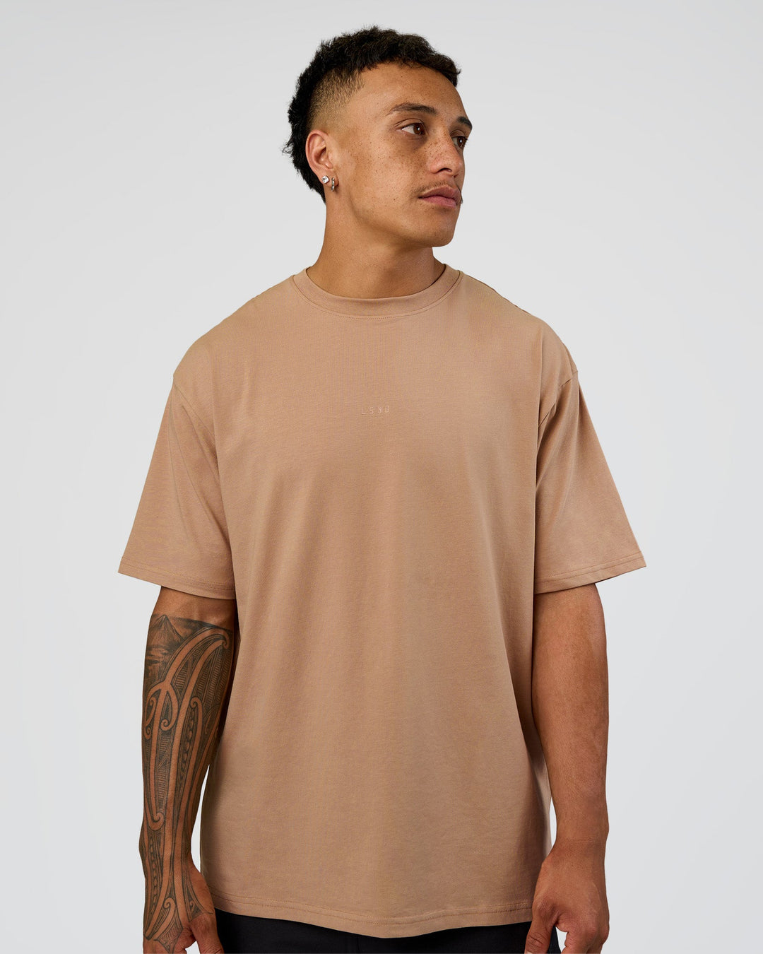 Man wearing Base FLXCotton Tee Oversized - Warm Smoke | Model:Daarian | Size:M