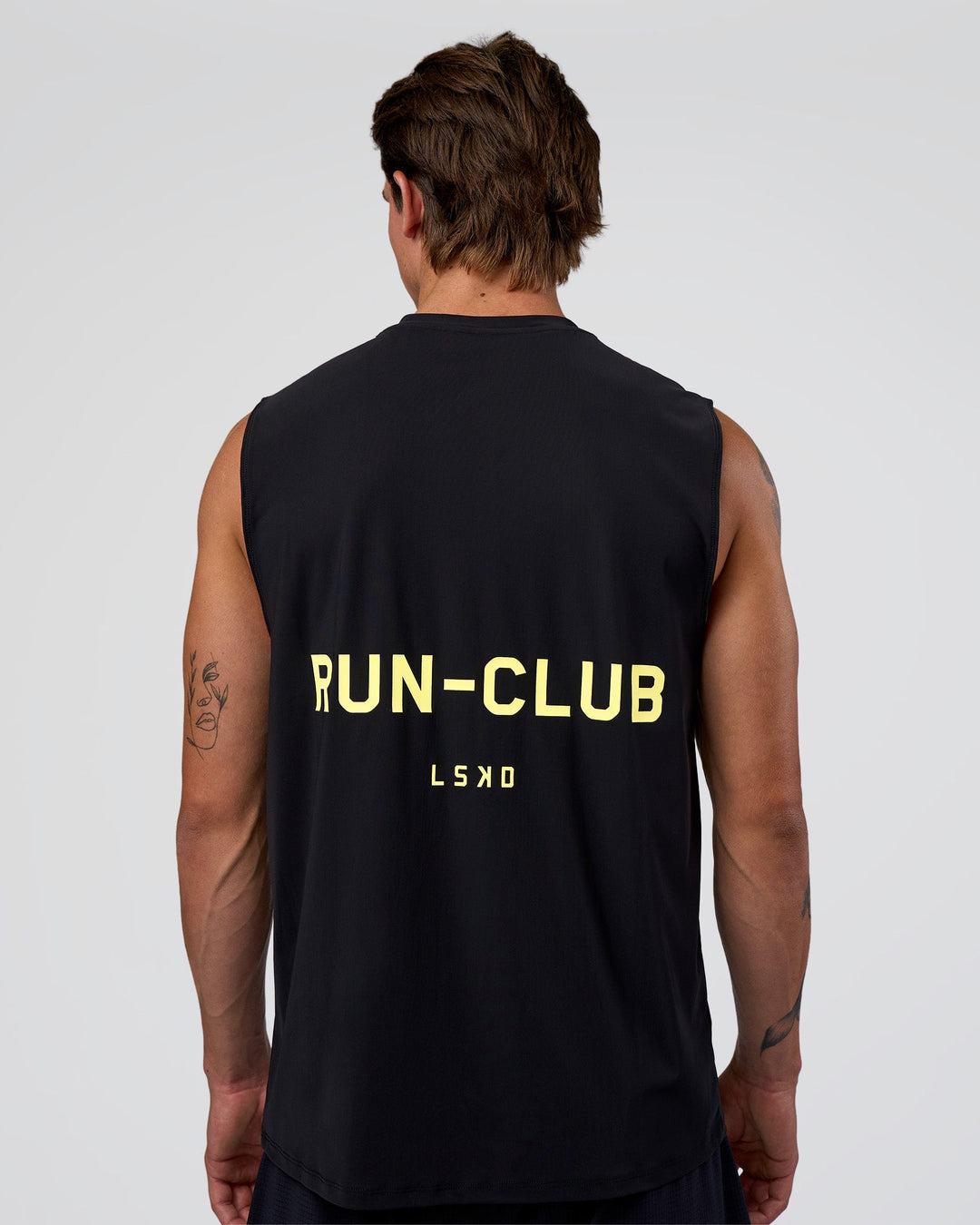 Man wearing Cadence RUN CLUB Muscle Tank - Black-Yellow Fizz | Model:Konnor | Size:M - view 1
