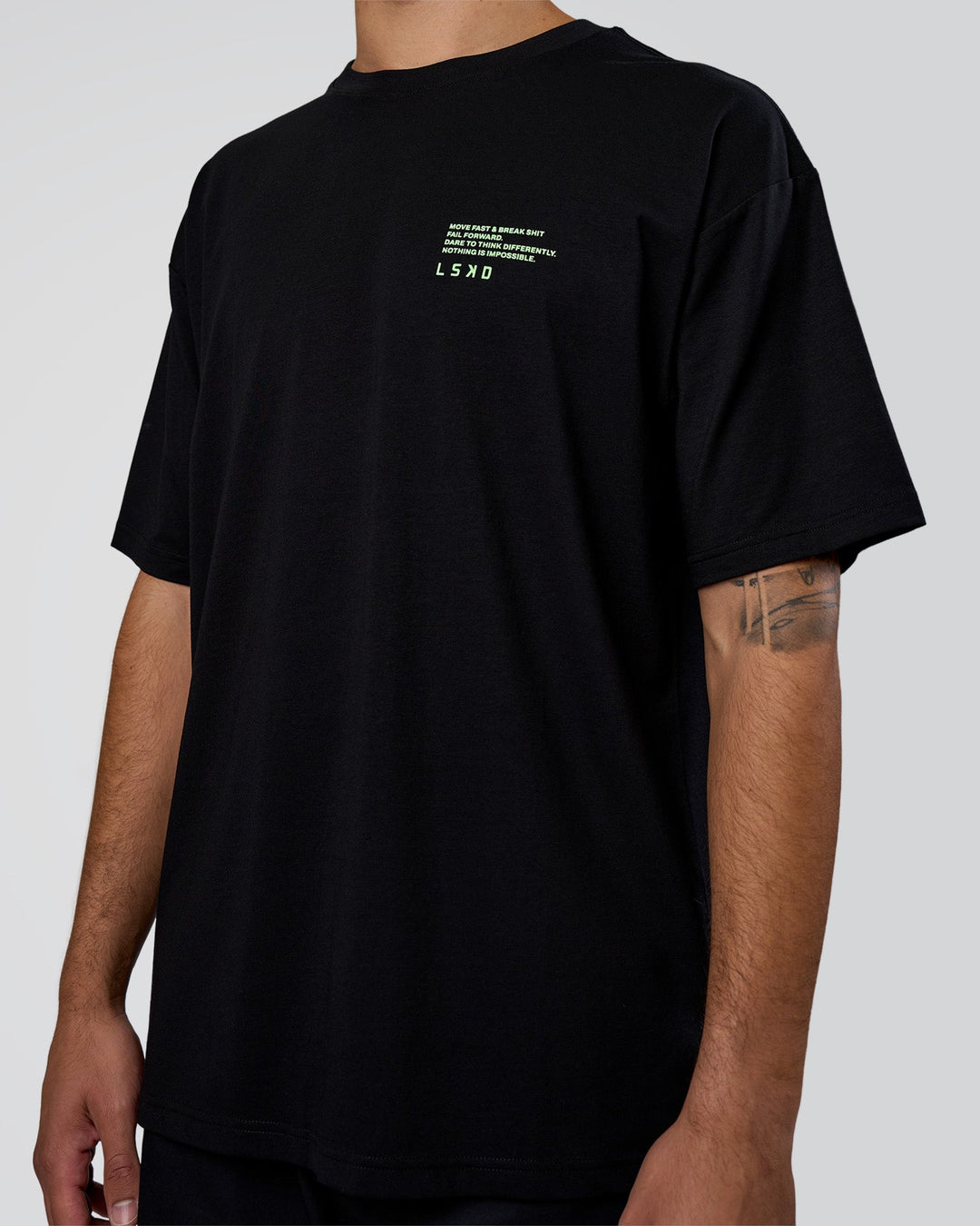 Man wearing Coffee Run FLXCotton Oversized Tee - Black-Solar Lime | Model:Zoran | Size:M