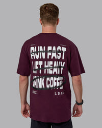 Man wearing Coffee Run FLXCotton Oversized Tee - Cherry Lacquer-Black | Model:Cameron | Size:M