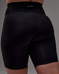 Woman wearing Fusion Ultra High-Rise 9" Short Pockets - Black | Model:Caity | Size:M
