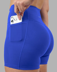 Woman wearing Fusion Ultra High-Rise 4" Short Pockets - Power Cobalt | Set:true | Angle:closeup | Model:Amy | Size:M