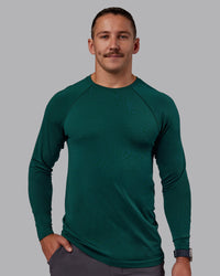 Man wearing AeroFLX+ Seamless Long Sleeve Tee - Dark Moss/Dark Moss | Model:Jaiden | Size:M