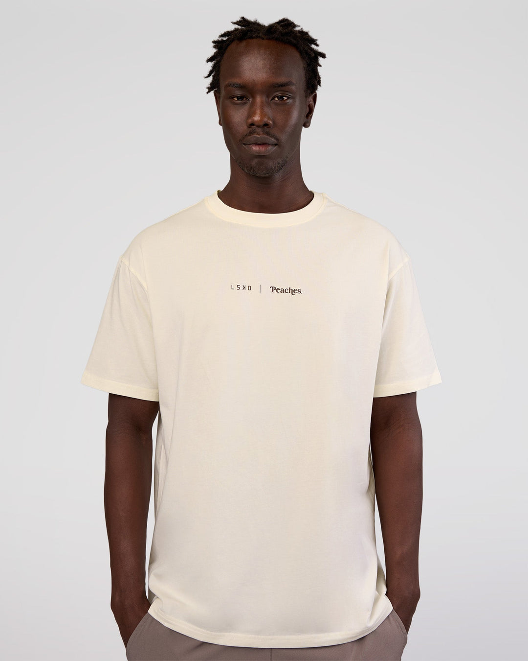 Man wearing Peaches x LSKD Collection FLXCotton Oversize Tee - Off White | Model:Okello | Size:M