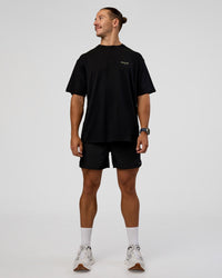 Man wearing RUN CLUB FLXCotton Tee Oversize - Black-Yellow Fizz | Model:Jaiden | Size:M