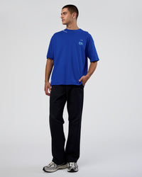 Man wearing Sticker Heavyweight Oversized Tee - Electric Indigo-Baltic Sea | Model:Zoran | Size:M