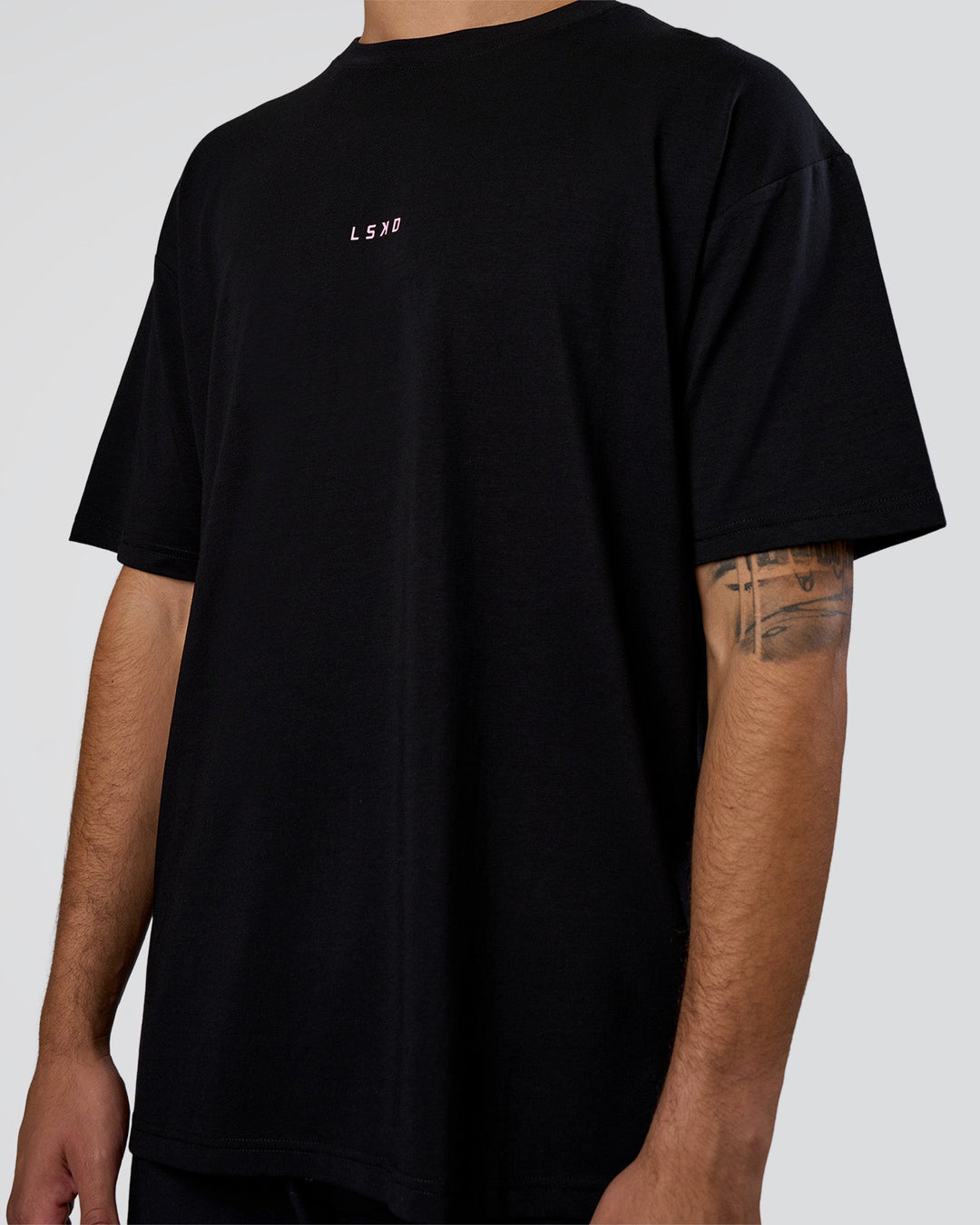 Man wearing Together We Rise FLXCotton Oversized Tee - Black-Candy Pink | Model:Zoran | Size:M