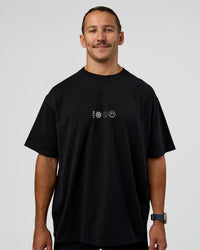 Man wearing Trust The Process Heavyweight Unisex Oversized Tee - Black-White | Model:Jaiden | Size:M