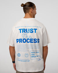 Man wearing Trust The Process Heavyweight Unisex Oversized Tee - Off White-Electric Indigo | Model:Jaiden | Size:M