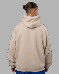 Man wearing Unisex Oversized Piping Hoodie - Shale Beige-Power Cobalt | Model:Jaiden | Size:M