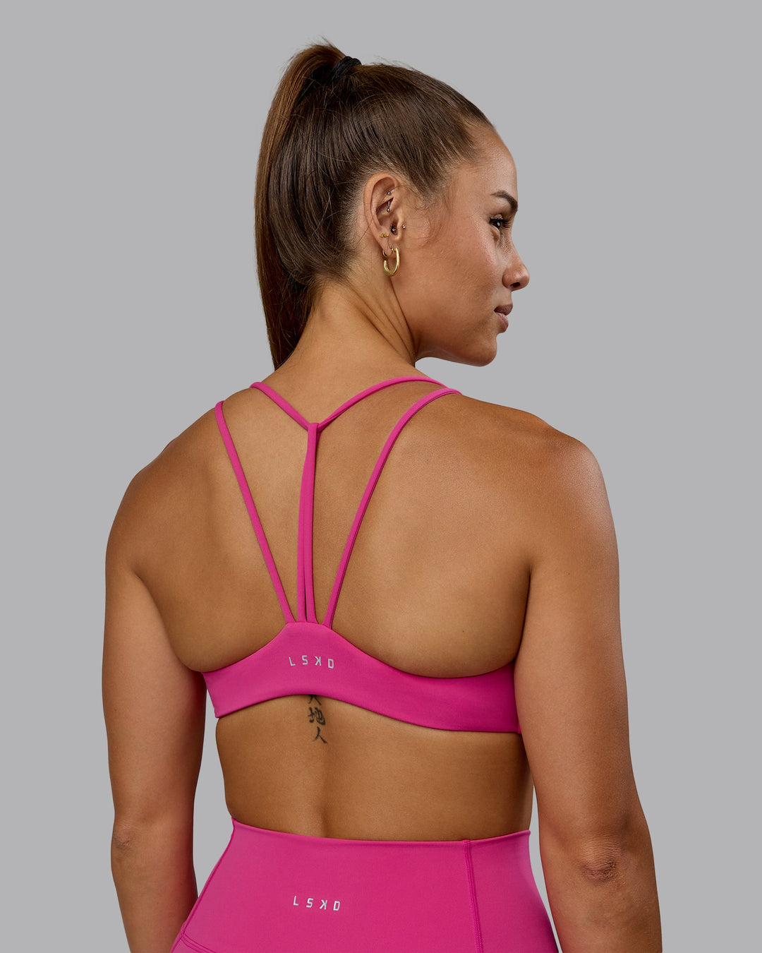 Woman wearing Agile Sports Bra - Fuchsia Pink