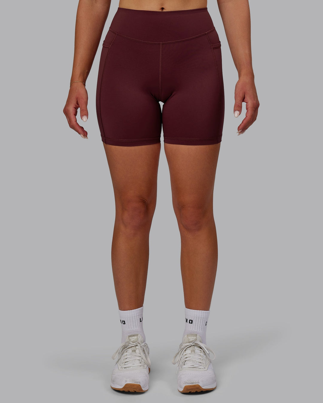 Woman wearing Elite Mid-Length Shorts - Dark Cherry