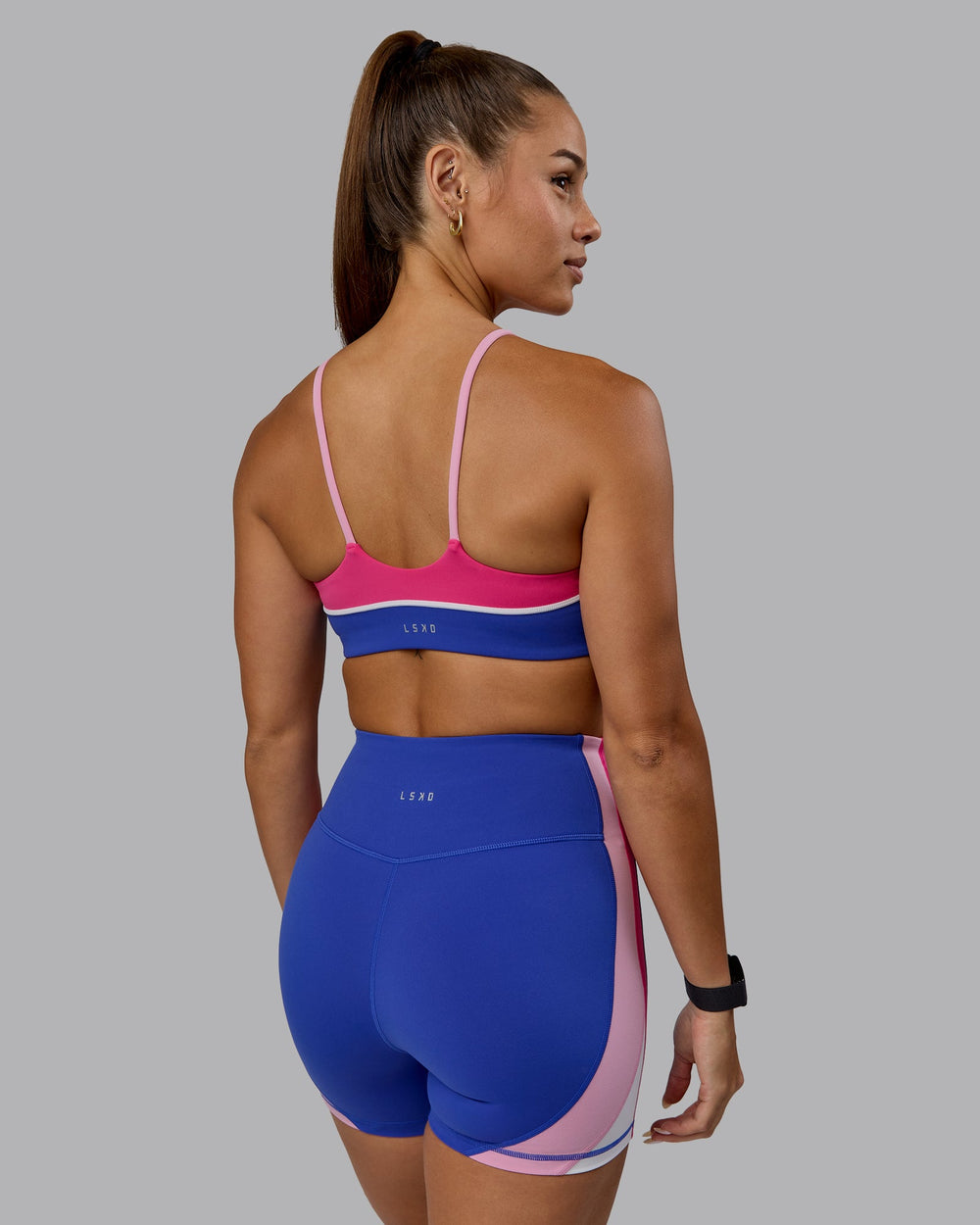 Woman wearing Embrace Sports Bra - Power Cobalt-Fuchsia Pink