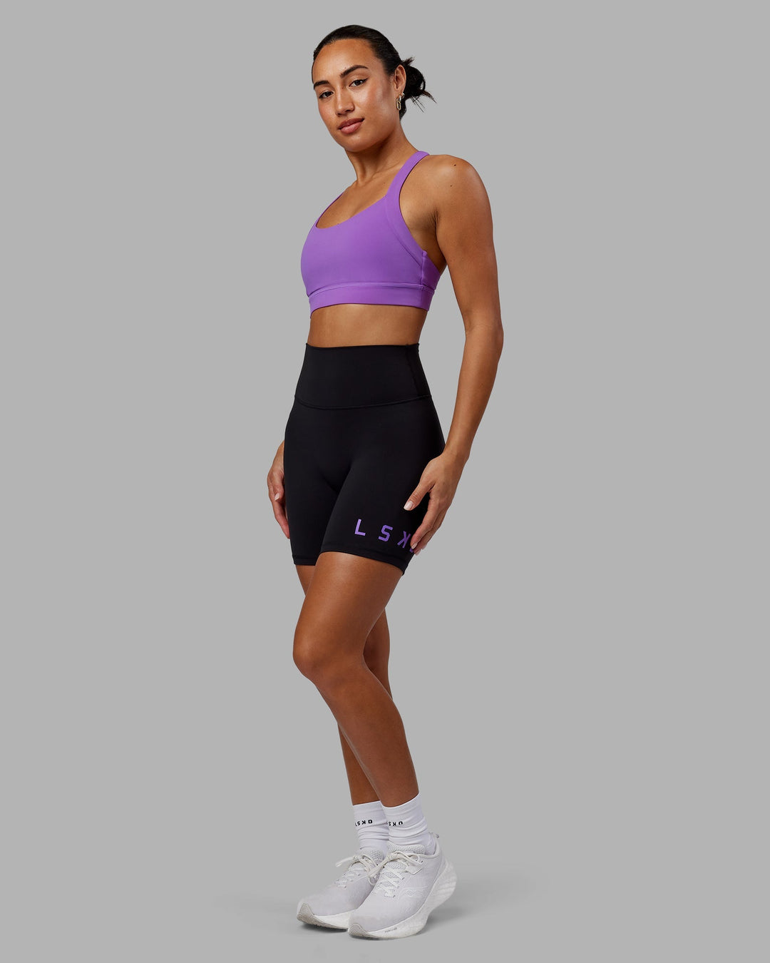 Woman wearing Evolved Mid-Length Shorts - Black-Purple Swirl