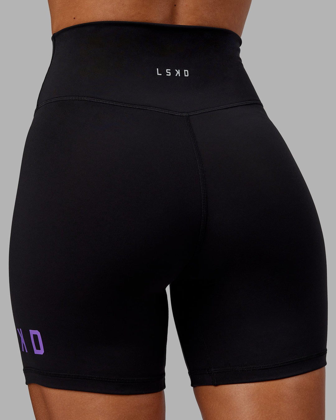 Woman wearing Evolved Mid-Length Shorts - Black-Purple Swirl