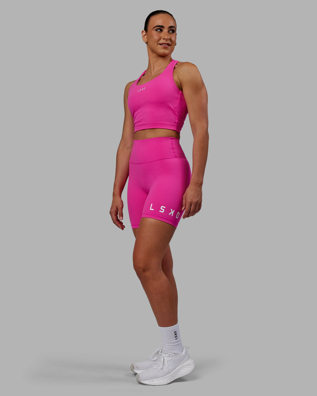 Woman wearing Evolved Mid Short Tights - Fuchsia Pink-White