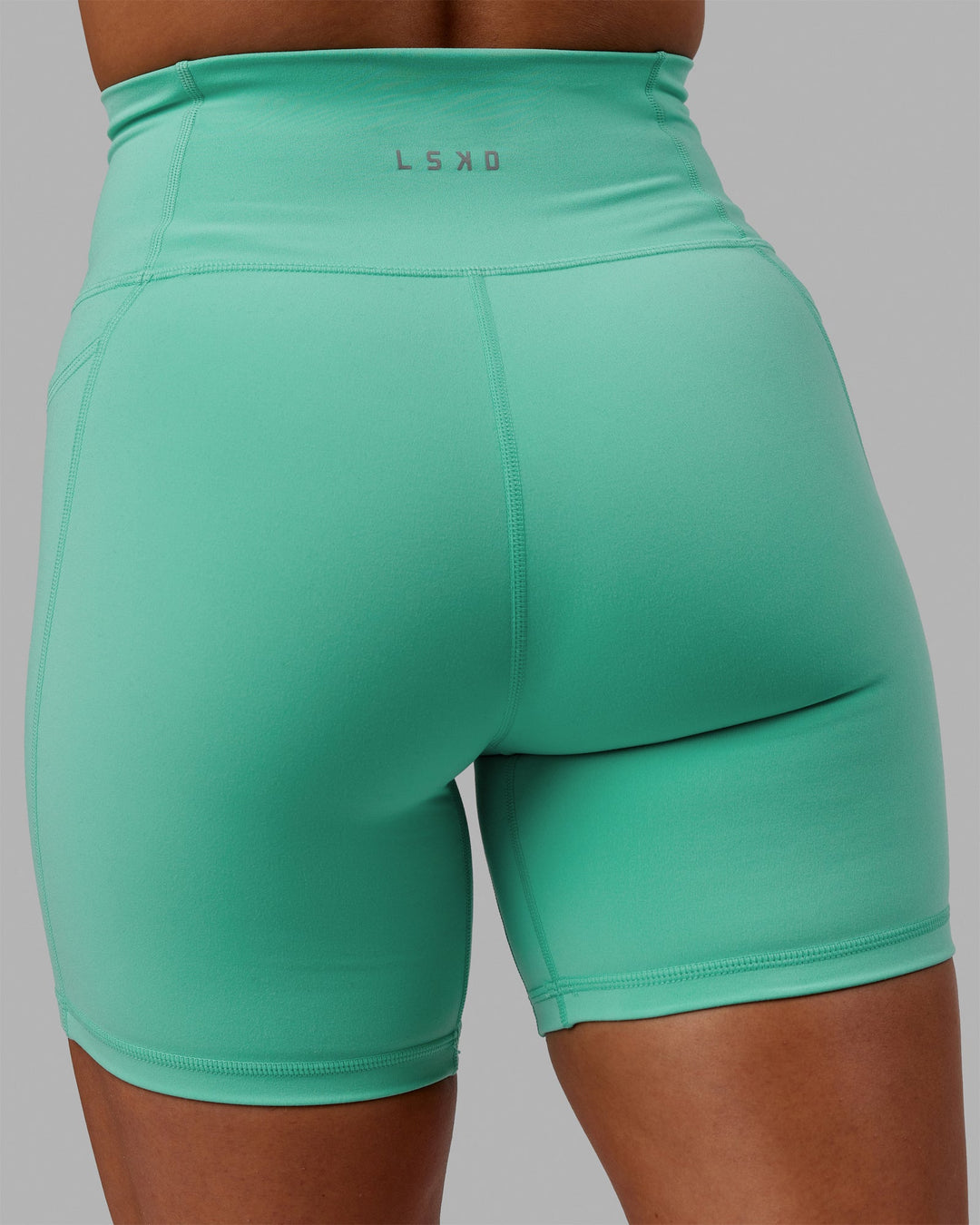 Woman wearing Fusion Ultra High-Rise 6" Short Pockets - Aquatic Awe | Model:Gabby | Size:S