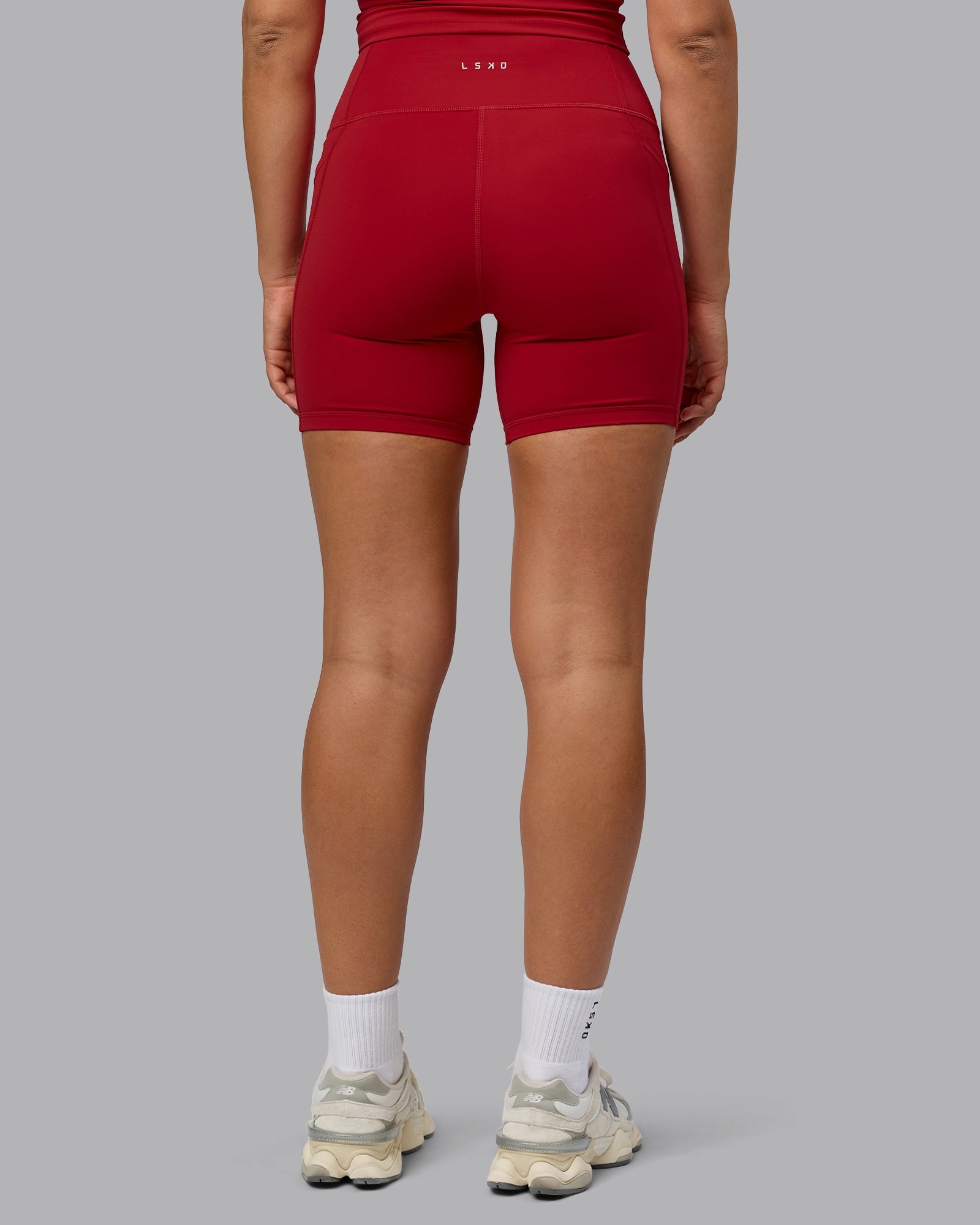 Woman wearing Fusion Ultra High-Rise 6" Short Pockets - Cherry Red | Model:Sophie | Size:S