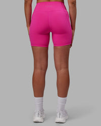 Woman wearing Fusion Ultra High-Rise 6" Short Pockets - Fuchsia Pink | Set:true | Angle:back | Model:Sophie | Size:S