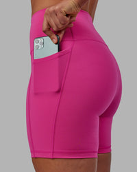 Woman wearing Fusion Ultra High-Rise 6" Short Pockets - Fuchsia Pink | Set:true | Angle:closeup | Model:Sophie | Size:S