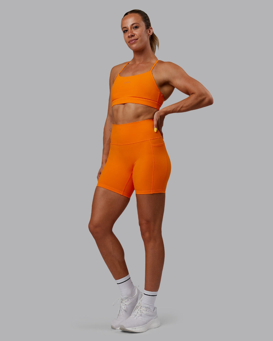 Woman wearing Fusion Mid-Length Shorts - Vibrant Orange