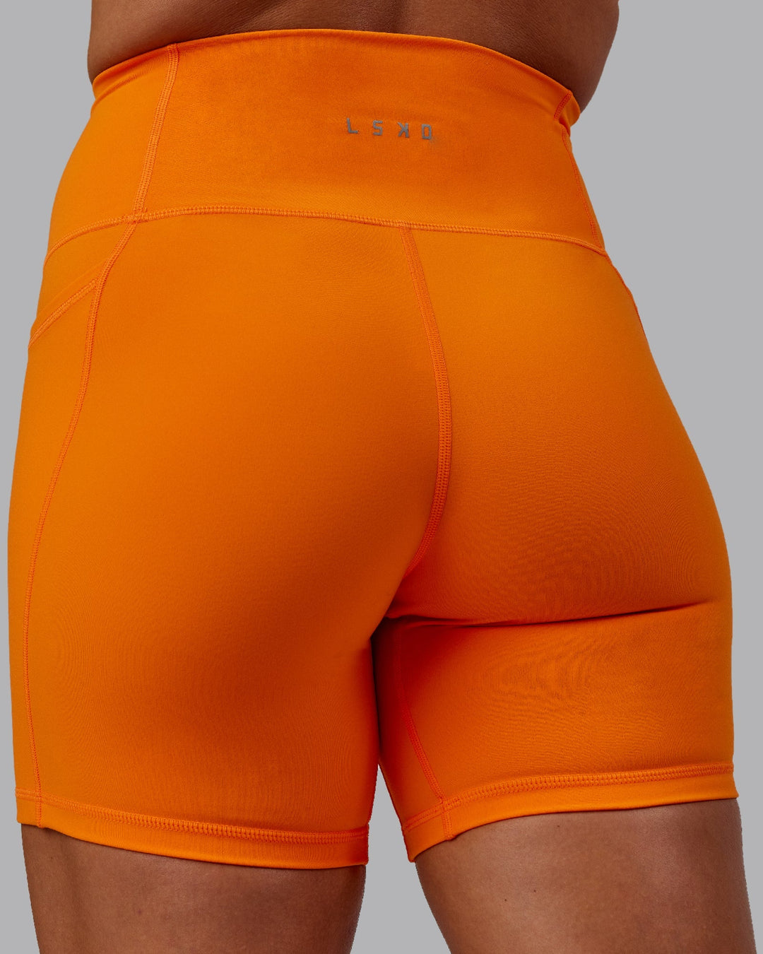 Woman wearing Fusion Mid-Length Shorts - Vibrant Orange