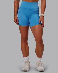 Woman wearing Fusion Ultra High-Rise 6" Short Pockets - Azure Blue | Set:true | Angle:front | Model:Amber | Size:S